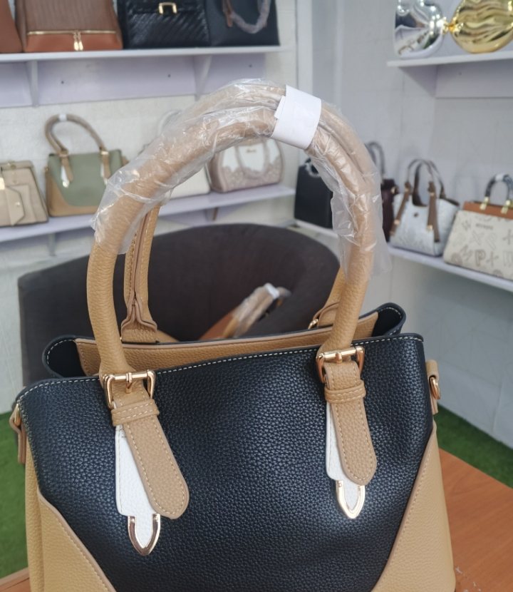 Black trapeze tote with buckle straps
